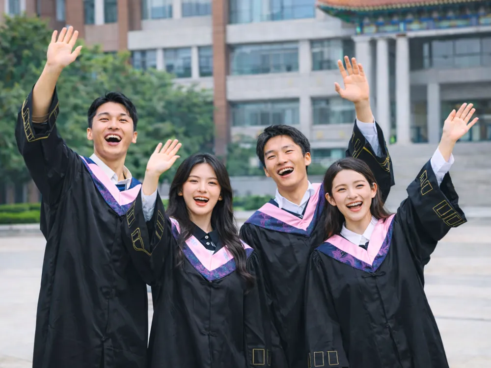 นักศึกษาสวมชุดครุยรับปริญญา ฉลองความสำเร็จหน้าตึกเรียนมหาวิทยาลัยจีน