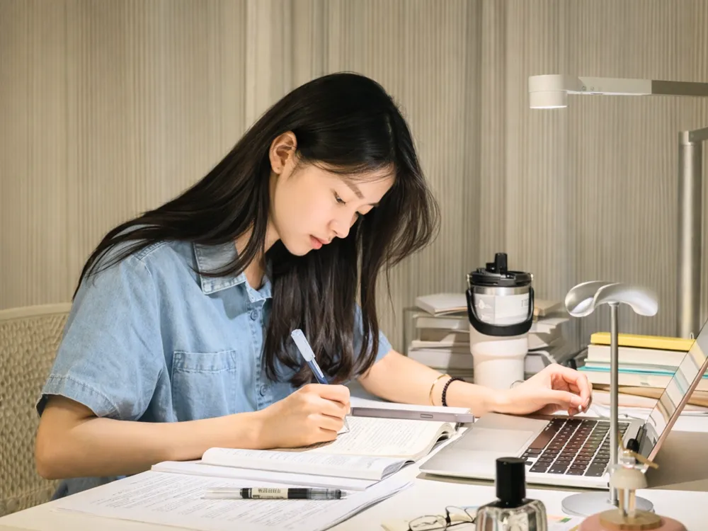 นักศึกษานั่งทำงานและอ่านหนังสือในห้องเรียน สะท้อนบรรยากาศการเรียนรู้