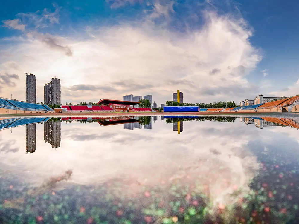สนามกีฬาหลักของมหาวิทยาลัย Hangzhou Dianzi University พร้อมภาพสะท้อนในแอ่งน้ำ
