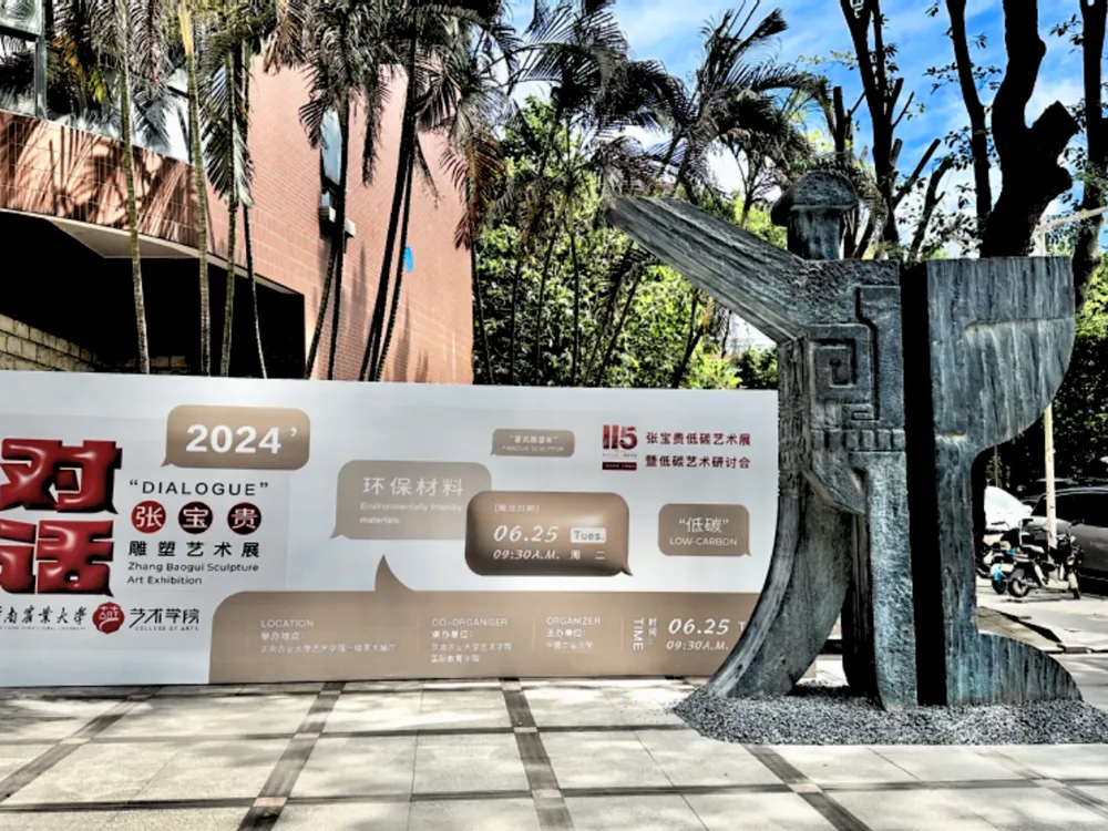 ประติมากรรมกลางแจ้งหน้าคณะศิลปะและการออกแบบ South China Agricultural University พร้อมแบนเนอร์นิทรรศการศิลปะสิ่งแวดล้อมปี 2024