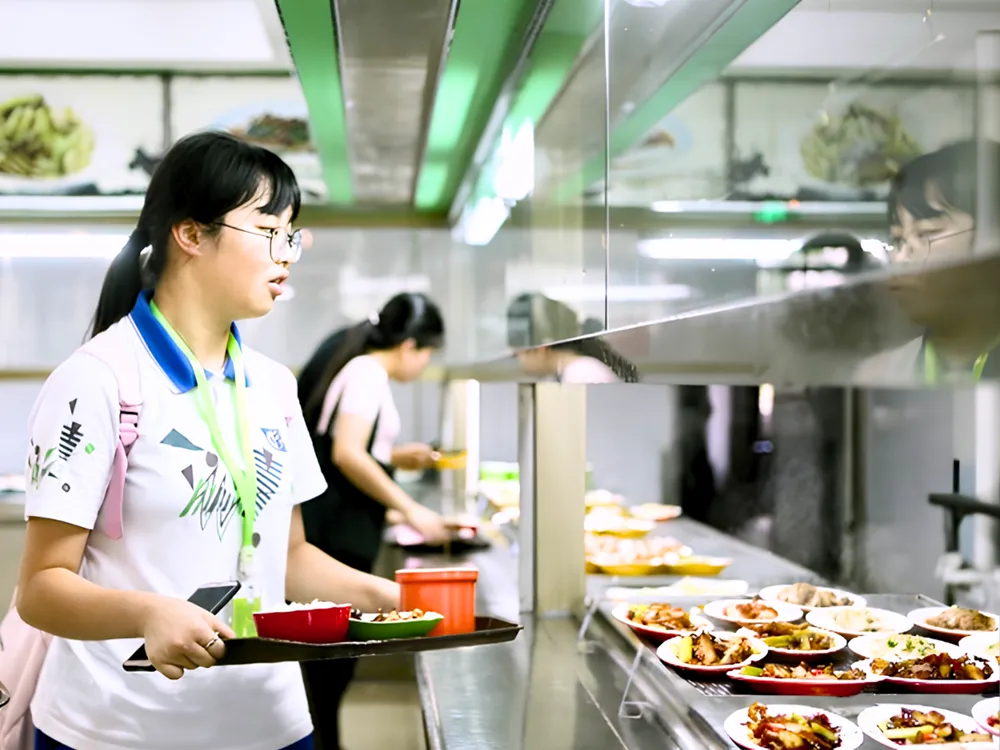 นักศึกษาเลือกอาหารจากเคาน์เตอร์บริการในโรงอาหารของ South China Agricultural University บรรยากาศการรับประทานอาหารร่วมกันในชีวิตประจำวัน