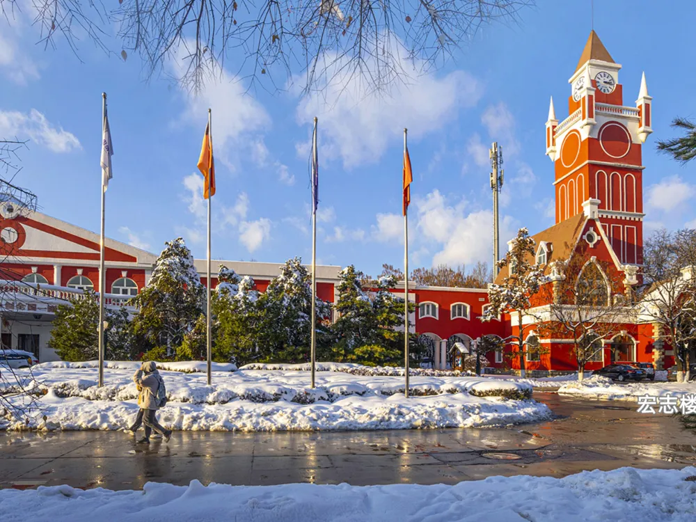 อาคารสไตล์ยุโรปสีแดงพร้อมหอคอยนาฬิกาในฤดูหนาว ภายในมหาวิทยาลัย Shenyang City Universit