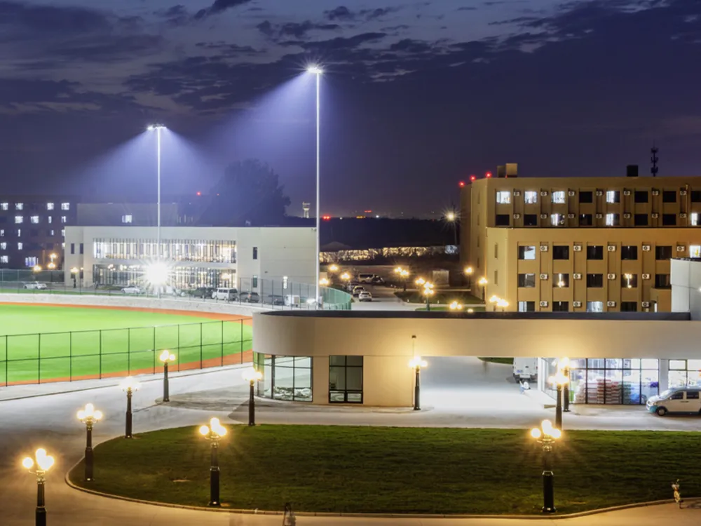 ภาพกลางคืนของวิทยาเขต Shenyang City University สนามกีฬาและอาคารเรียนสว่างไสว