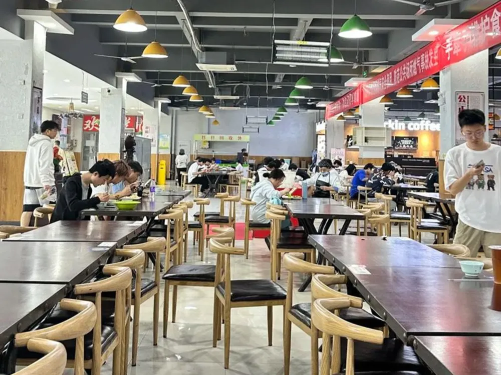 โรงอาหารมหาวิทยาลัย Yancheng Institute of Technology พร้อมโต๊ะไม้และร้าน Luckin Coffee
