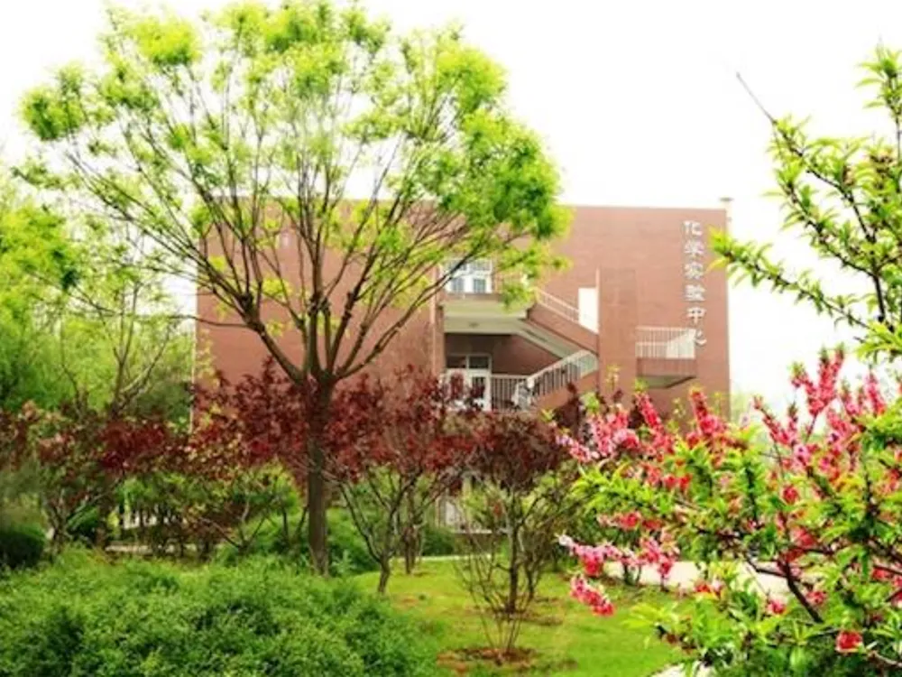 อาคาร Chemistry Experiment Center ของ Yancheng Institute of Technology รายล้อมด้วยต้นไม้และดอกไม้บาน