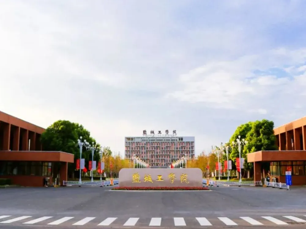 ทางเข้าหลักมหาวิทยาลัย Yancheng Institute of Technology พร้อมอนุสาวรีย์หินและอาคารเรียนสมมาตรสองฝั่ง