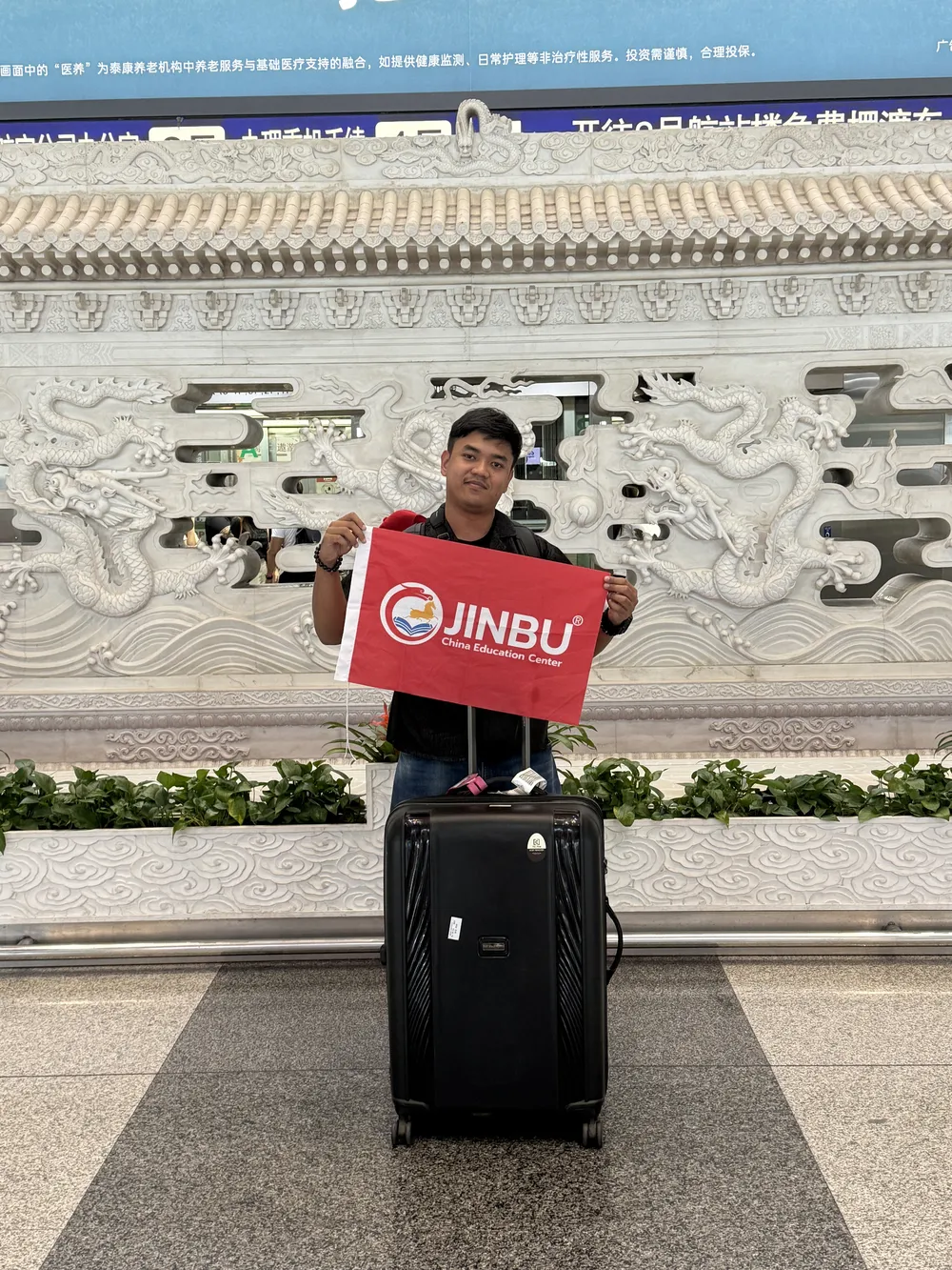 นักศึกษากับป้าย Jinbu บริเวณสนามบินปักกิ่ง